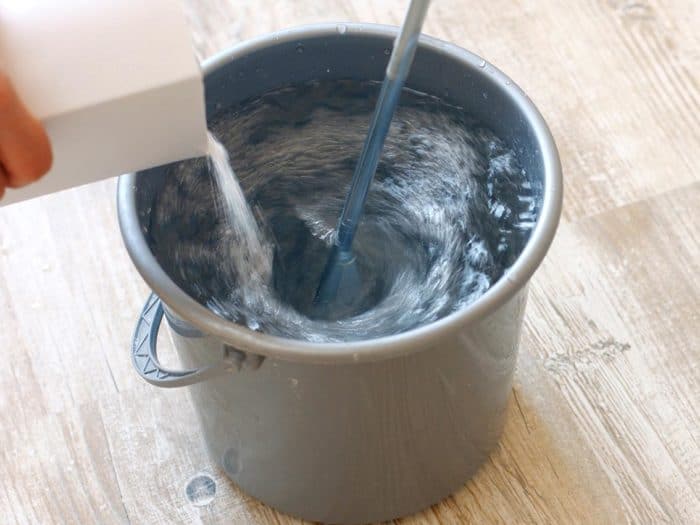Pouring wallpaper paste in to a bucket wallcovering latex